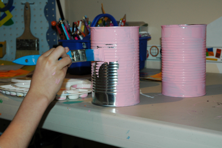 K paints a tin can pink for B